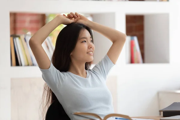 Calm asian student girl sitting at desk resting after study — ストック写真