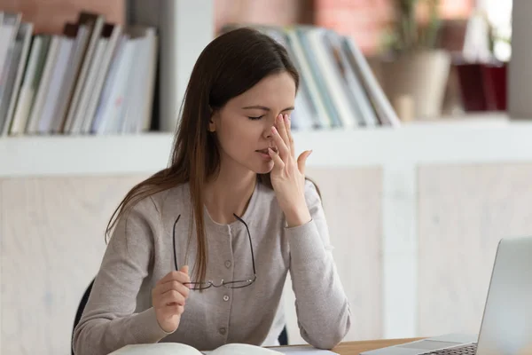 Studente tolto gli occhiali riduce la tensione oculare dopo lungo studio — Foto Stock