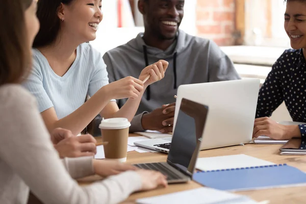 Multinational group of students take break chatting laughing in classroom — ストック写真