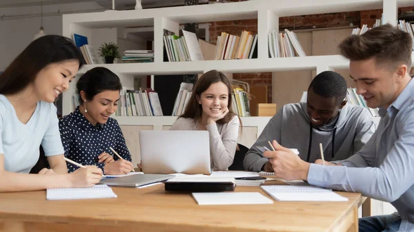 Studenti multirazziali studiano insieme seduti alla scrivania della biblioteca — Foto Stock