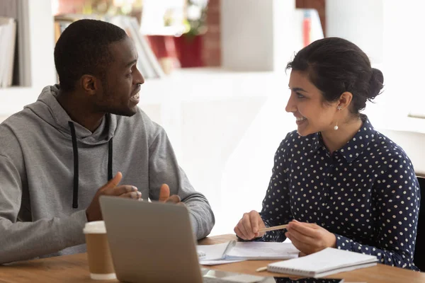 African guy indian girl sitting at desk doing common task — Stock Photo, Image