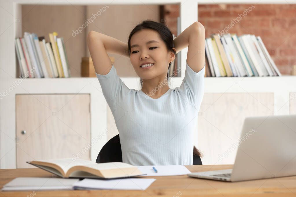 Asian girl finished studying resting put hands behind head