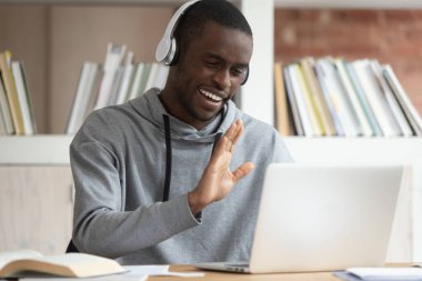 Kulaklıklı Afrikalı adam internetten selamlama videosu çekiyor.