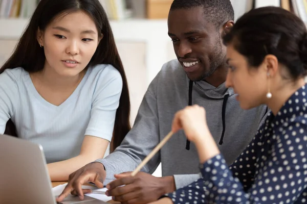 Multi-ethnic students sitting in classroom using computer educational apps — Stock Photo, Image