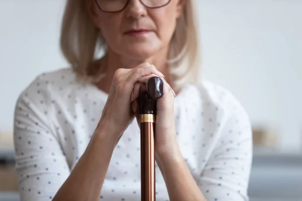 Depresivní starší žena držící hůl, zblízka pohled — Stock fotografie