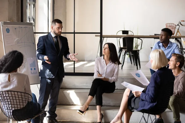 Treinador executivo masculino confiante falando com o grupo de funcionários durante a oficina — Fotografia de Stock