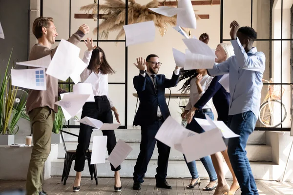 Spännande glad multiracial business team dans kasta papper på kontoret — Stockfoto