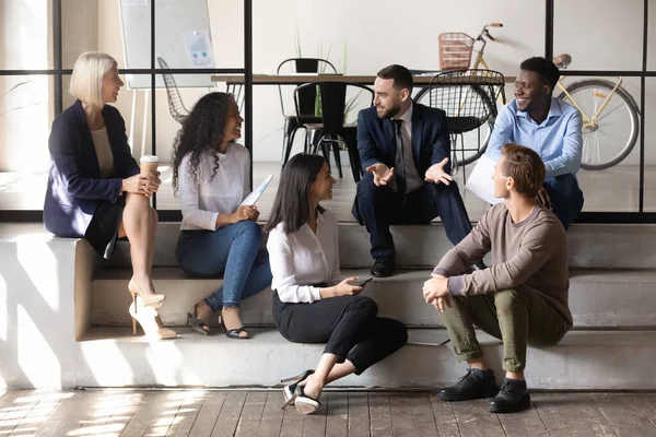 Personas de negocios multirraciales felices comunicarse sentarse en el piso de la oficina moderna — Foto de Stock