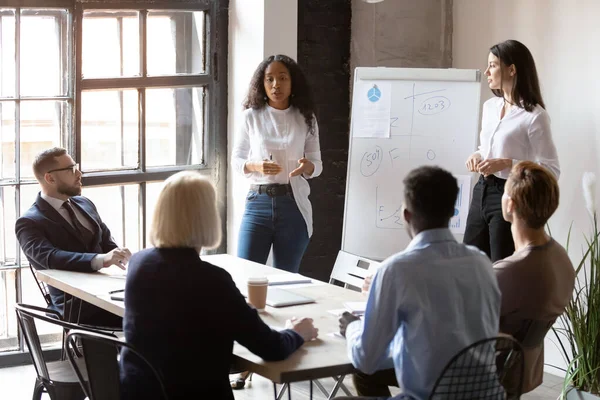 Olika kvinnliga tränare laget ger blädderblock presentation vid träning — Stockfoto