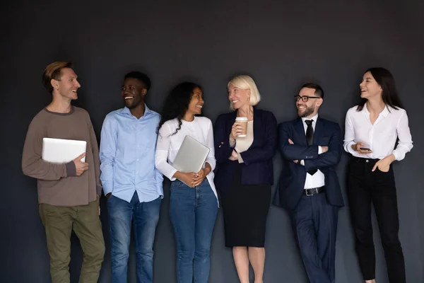 Happy multiracial professional business people laughing standing near wall — Stock Photo, Image