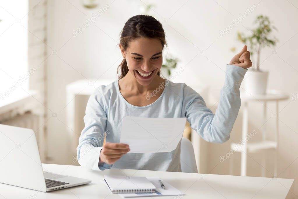 Overjoyed millennial mixed race female worker celebrating special achievement.