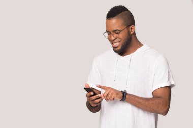 Gülümseyen melez adam kablosuz internet ile modern cep telefonu kullanıyor.