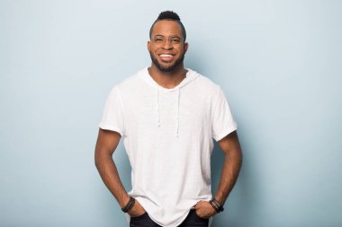 Gözlüklü gülümseyen Afrikalı Amerikalı stüdyoda poz veriyor.