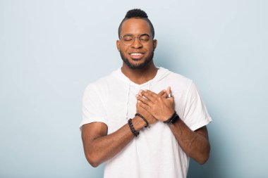 Minnettar Afrikalı Amerikalı adam ellerini kalbinde tut ve dua et.