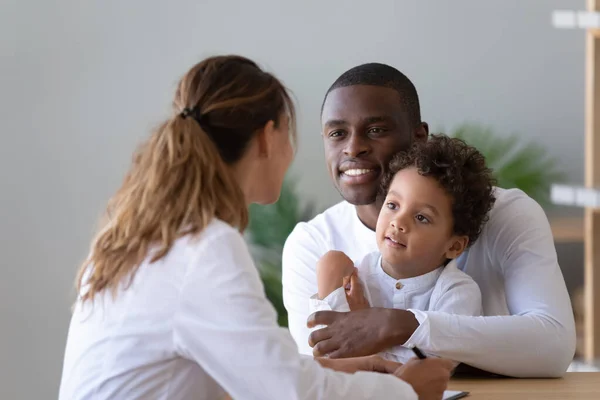 Papá afroamericano con hijo pequeño visita pediatra femenina — Foto de Stock