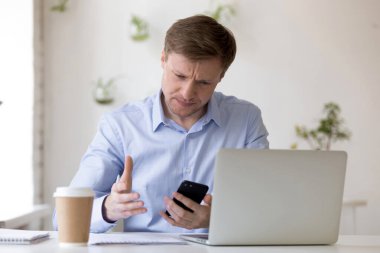 Kötü cep telefonu işinden rahatsız olan stresli genç adam..