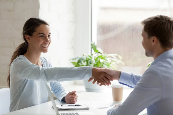 Glimlachende gemengde ras zakenvrouw schudden handen met zelfverzekerde mannelijke partner. — Stockfoto