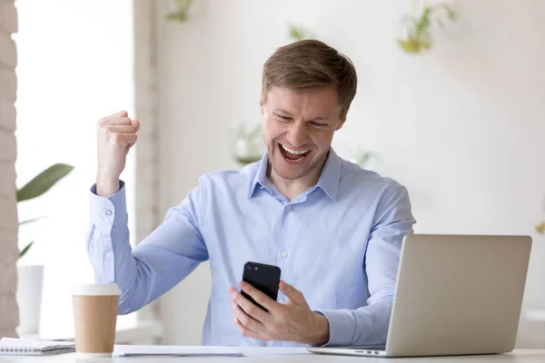 Overjoyed young businessman received message with good news. — Stock Photo, Image
