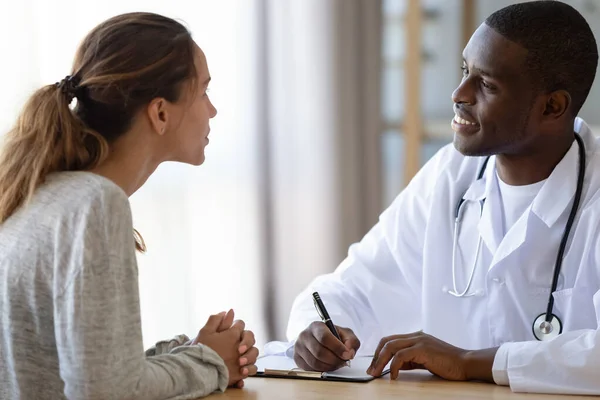 Afroamerikansk manlig läkare konsulterar kvinnlig patient — Stockfoto