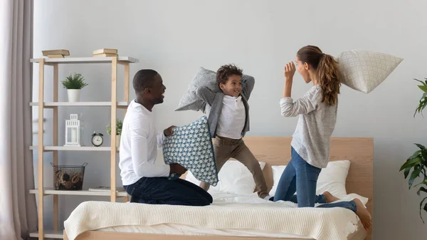 Gelukkig multinationaal familie kussen gevecht in de slaapkamer — Stockfoto
