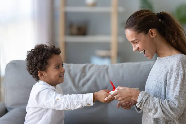 Pequeño niño regalo de cumpleaños a mamá emocionada — Foto de Stock