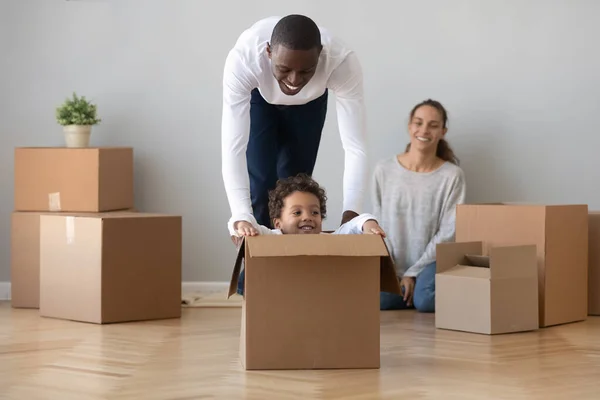 Feliz africano americano papá jugando con hijo en mudanza día — Foto de Stock