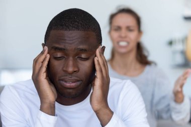 Sinirli Afro-Amerikan erkeği karısının tartışmasını dinlemekten kaçınır.