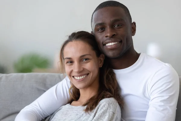 Portrait of happy international couple relaxing on couch — Stock Photo, Image