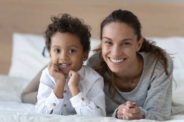 Porträtt av leende ung mamma poserar med biracial son — Stockfoto