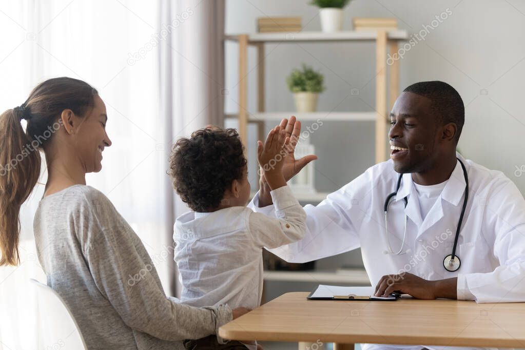 Little boy patient give high five to doctor at checkup