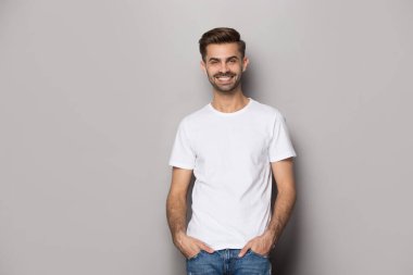 Smiling Caucasian man posing on grey studio background