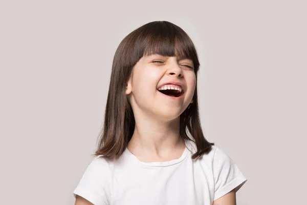 Overjoyed little girl have fun laughing at funny joke — Stock Photo, Image