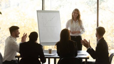 İş dünyası seyircileri, konferans semineri için mutlu bayan sunucuyu alkışlıyor.