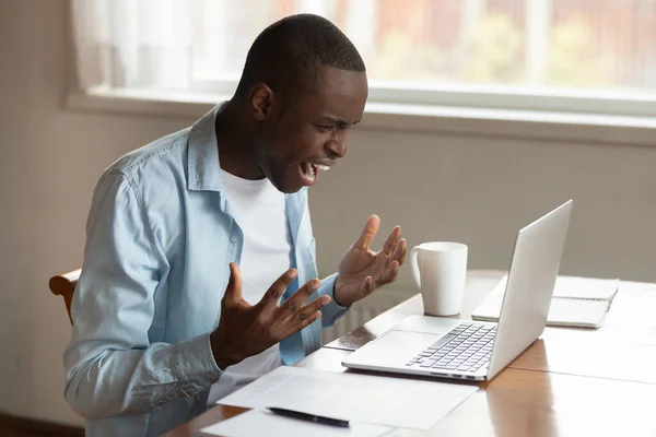 Estressado milenar Africano etnia cara irritado por computador quebrado . — Fotografia de Stock