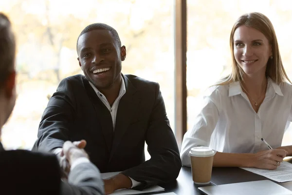 Smiling african male hr handshake applicant at job interview — Stock Photo, Image