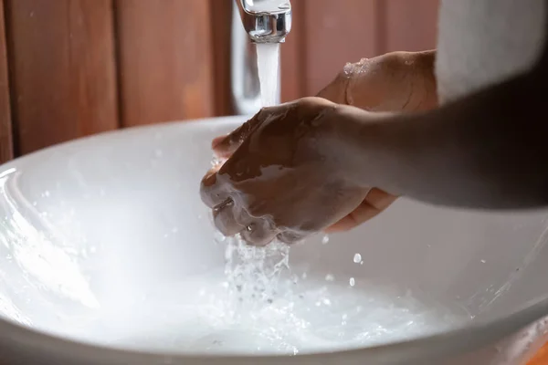 Joven africano de origen étnico lavándose las manos bajo agua corriente . —  Fotos de Stock