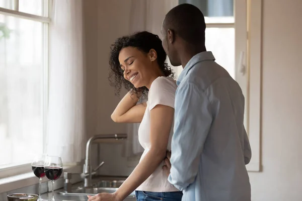 Smiling african american woman taking hair away, listening to husband. — Stok Foto