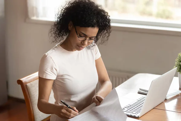 Concentrated young african american business woman signing documents, medical insurance. — Stock Photo, Image