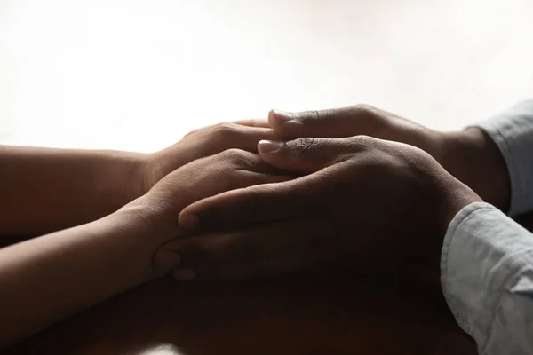Close-up millennial afrikaanse amarican liefdevolle man houden vrouwen handen. — Stockfoto