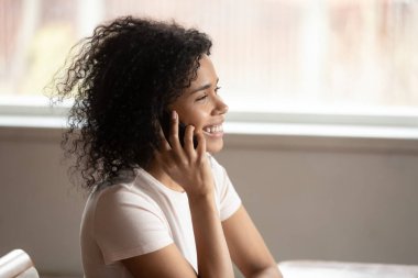 Mutlu Afro-Amerikan genç bayan cep telefonuyla konuşuyor..
