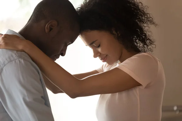 Side view happy african american woman cuddling beloved husband neck. — Stock Photo, Image