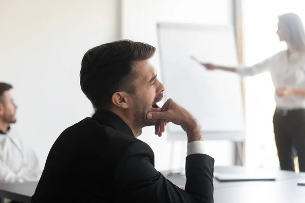 Bored businessman feel tired sleepy yawning during corporate presentation meeting