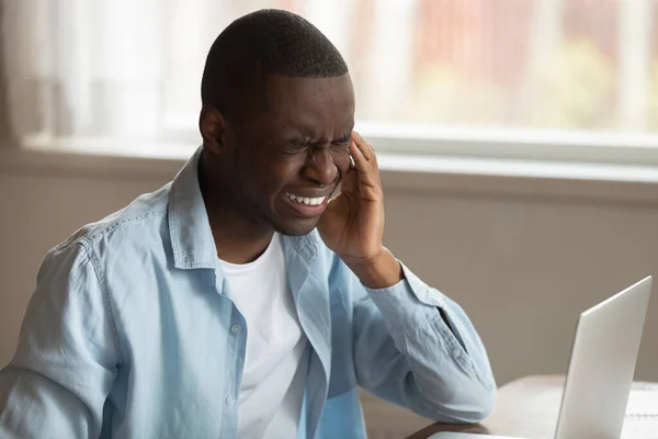 Olycklig trött afrikansk amerikansk kille lider av plötslig stark huvudvärk. — Stockfoto