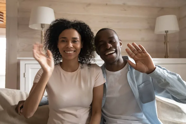 Feliz pareja afroamericana de la familia saludando, sentado en el sofá . —  Fotos de Stock