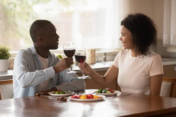 Glad leende afrikansk familj par hålla glas vin. — Stockfoto