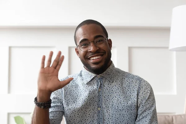 Smiling black man waving talking on video call — Stockfoto