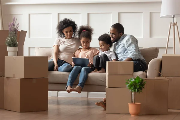 Happy black family with kids relax on sofa with tablet — Stock Photo, Image