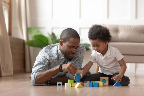 Loving zwarte vader spelen met zoon met het bouwen van bakstenen — Stockfoto
