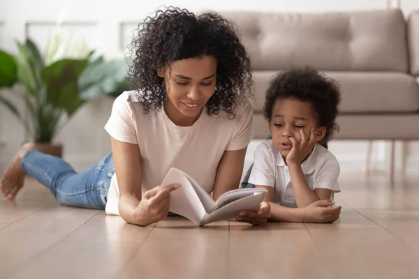 Jong zwart mam lezen boek met zoon thuis — Stockfoto