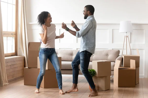 Happy black couple dancing in living room on moving day — Stock Photo, Image